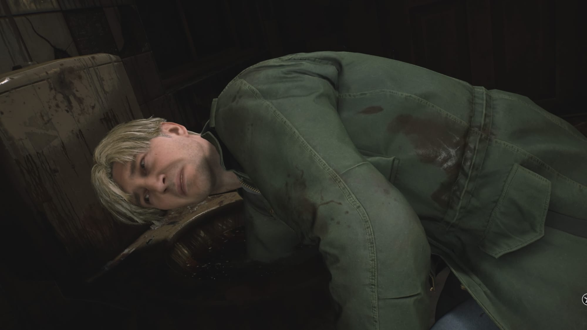 Man with a slightly bloodied jacket leaning over