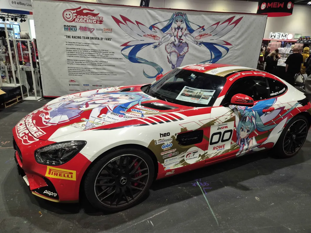 A red and white racing car with Hatsune Miku branding across it